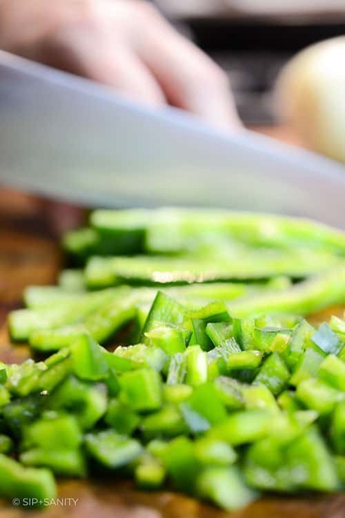 peppers being diced with a chef's knife