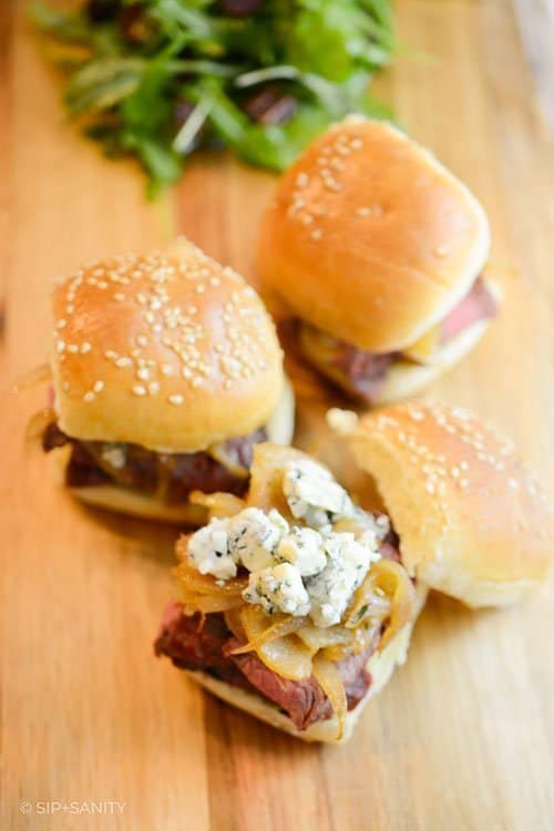 steak sliders with caramelized pears, onions and gorgonzola on a board