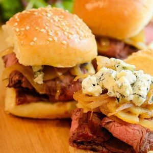 steak sliders with caramelized pears, onions and gorgonzola on a board