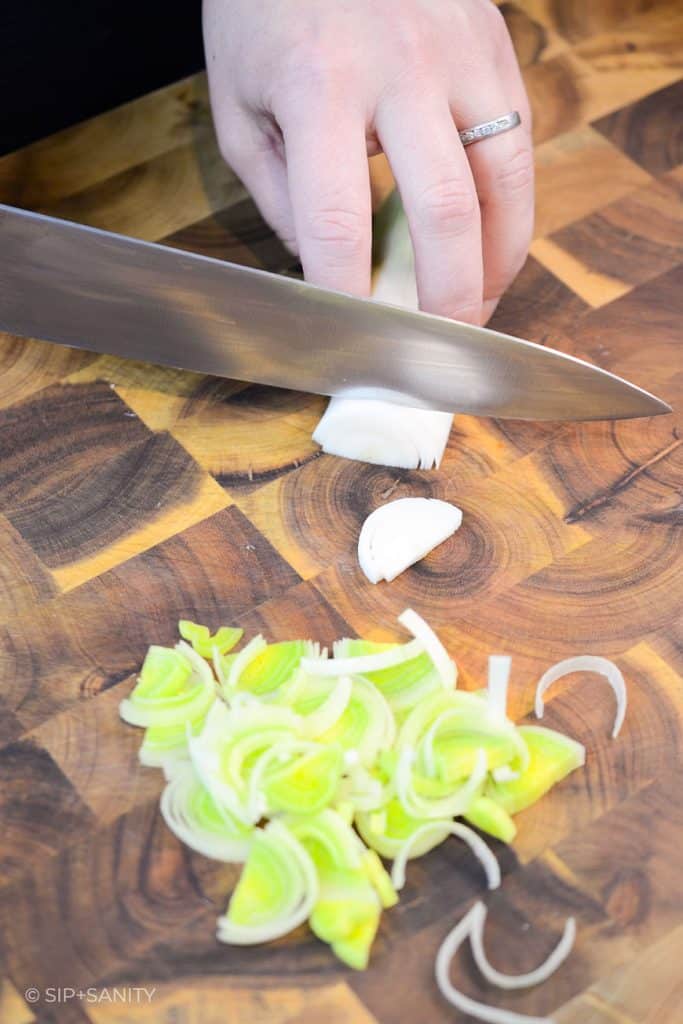 hands slicing leeks with a knife