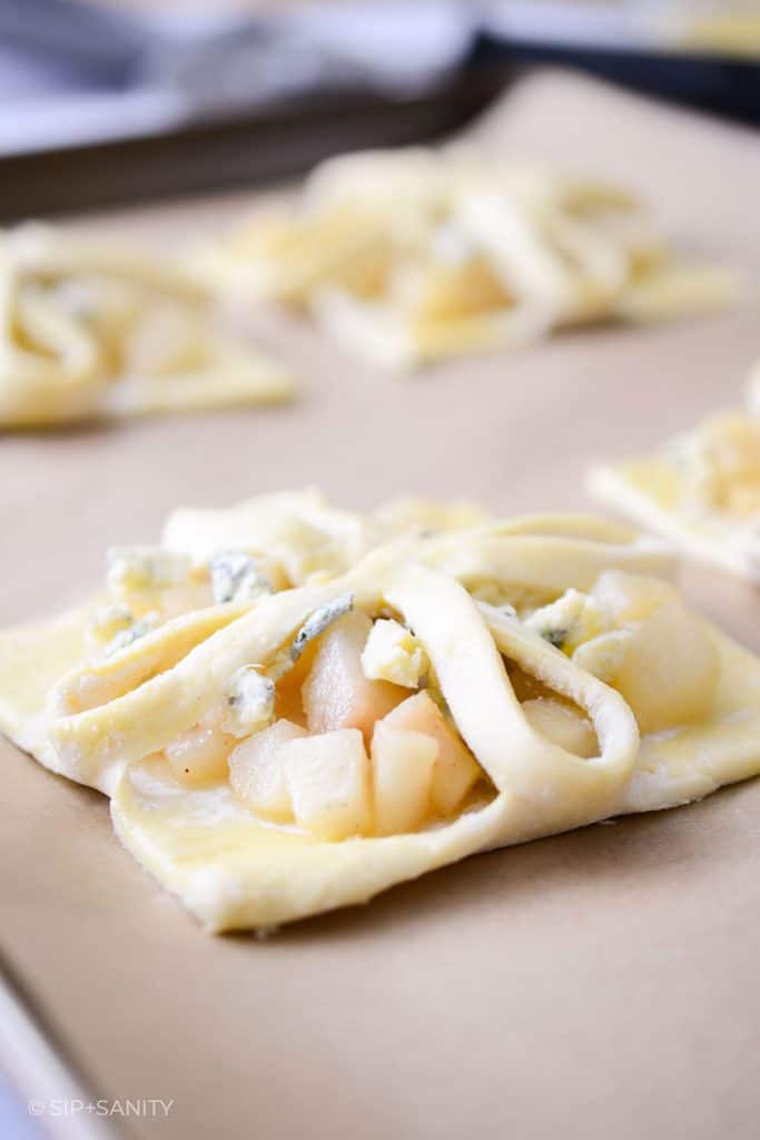 raw cashel blue cheese and pear tarts on a sheet pan