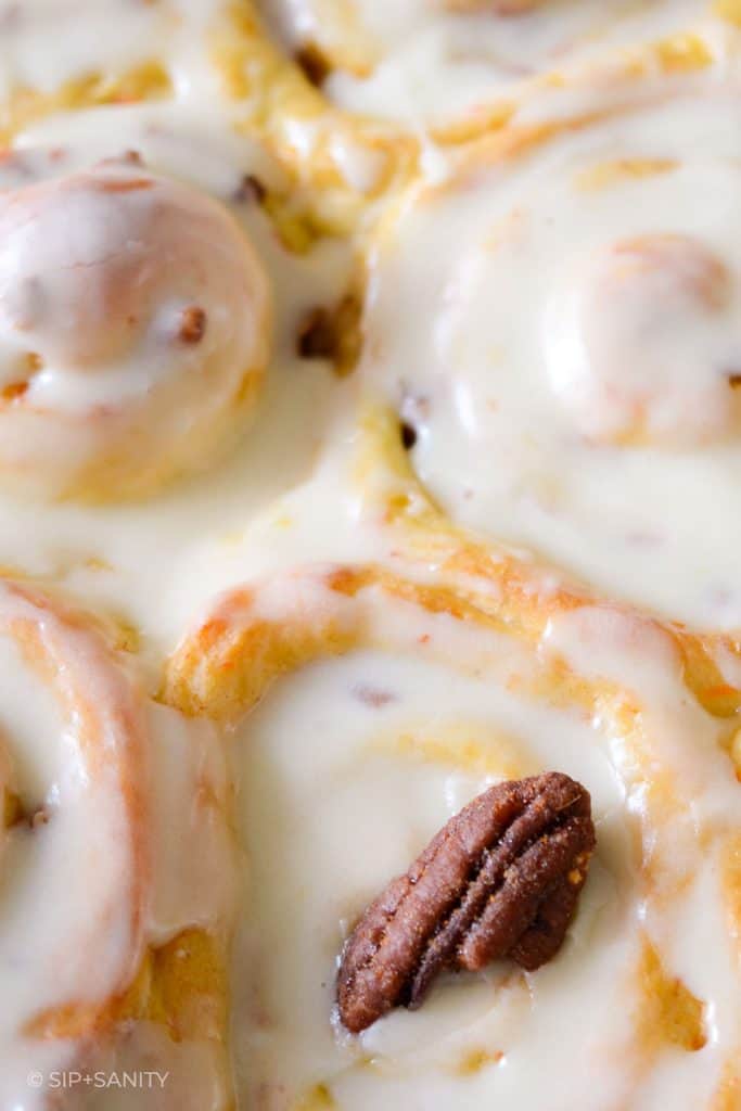 close up of carrot cake cinnamon rolls and a pecan