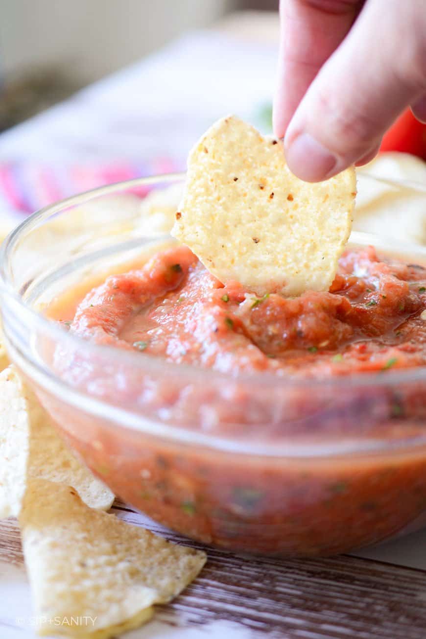 Dipping a chip into simple tomato salsa.