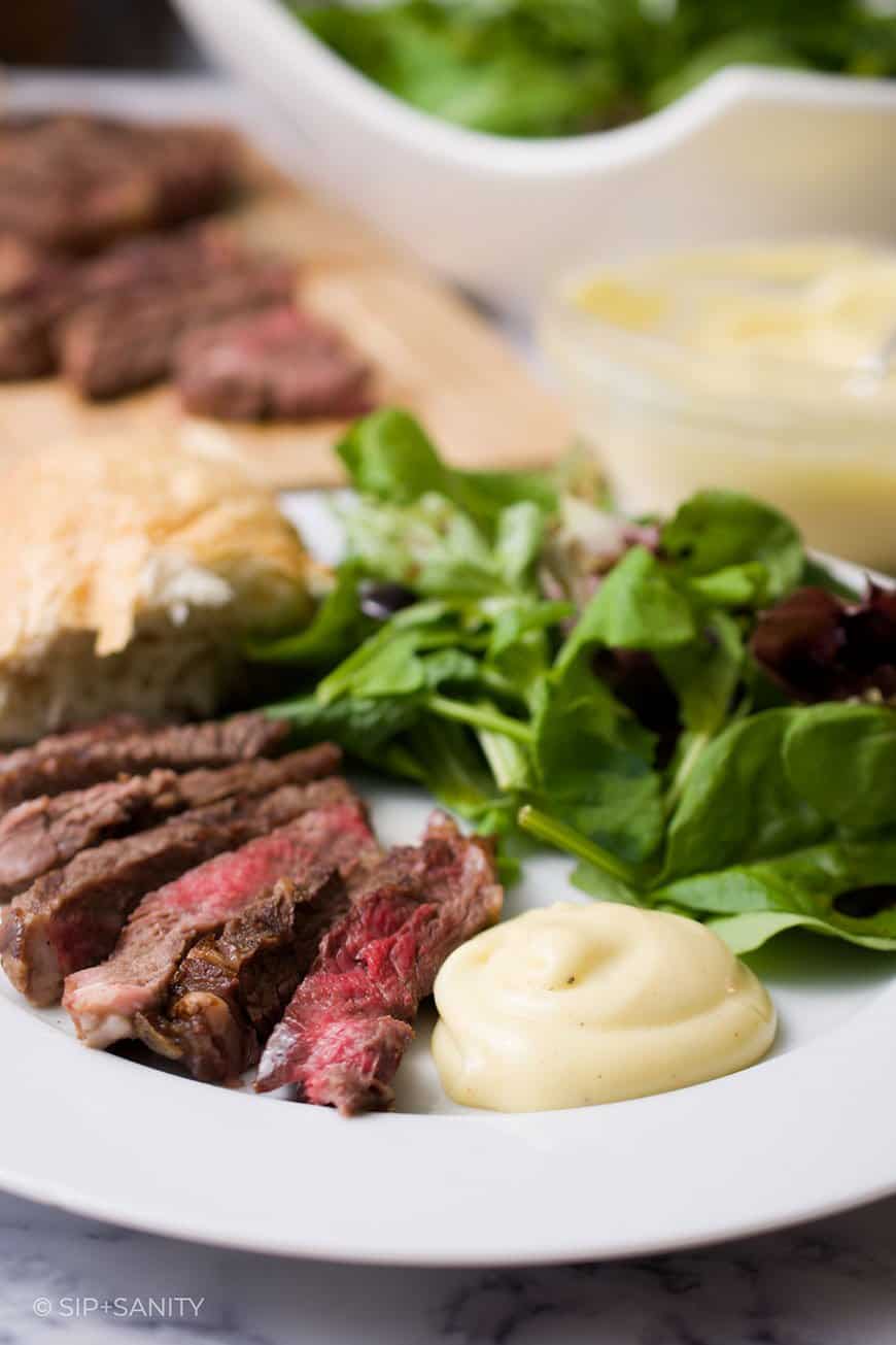 steak, salad, and French mayonnaise on a plate