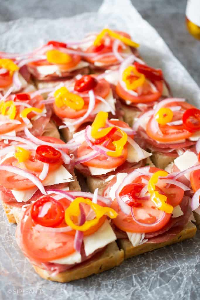 sliders with meat, cheese, tomatoes and banana peppers