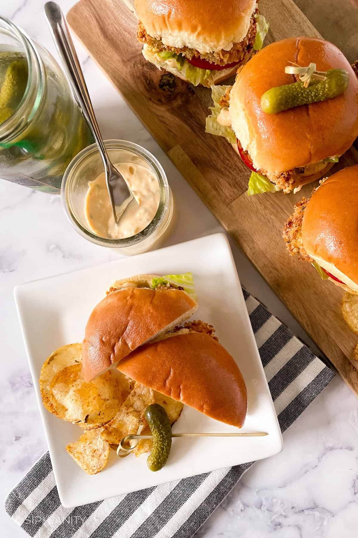 overhead image of a serving board of chicken sliders, and one a plate