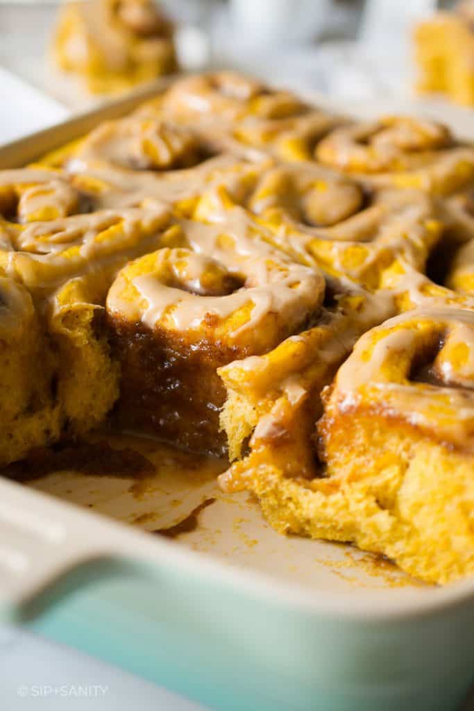 a pan of sweet rolls with a couple missing