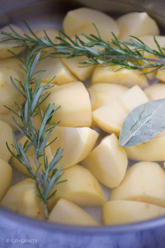 cut potatoes in a pot of water with rosemary and bay leaf