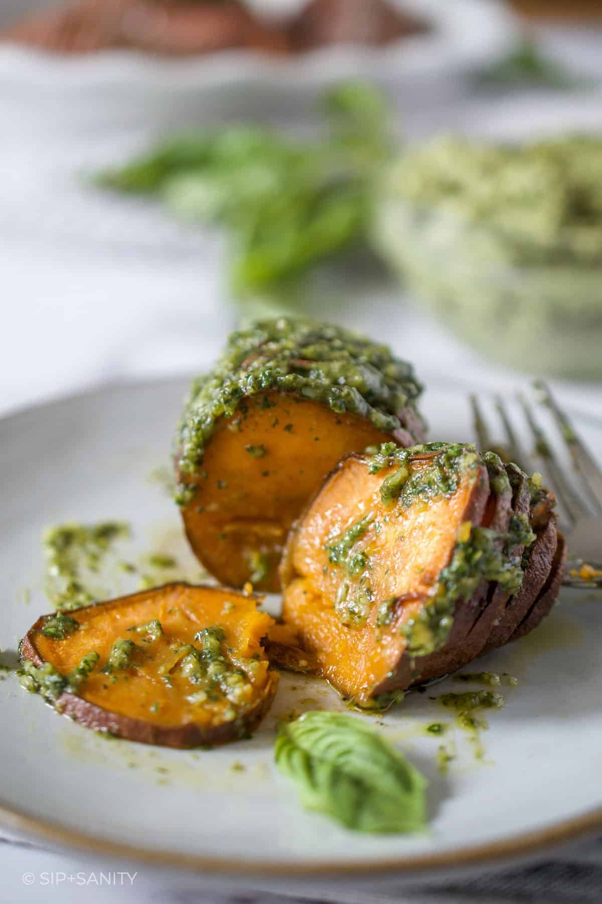 hasselback sweet potato with pesto butter on a plate
