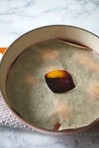saucepan of poaching liquid with parchment on top