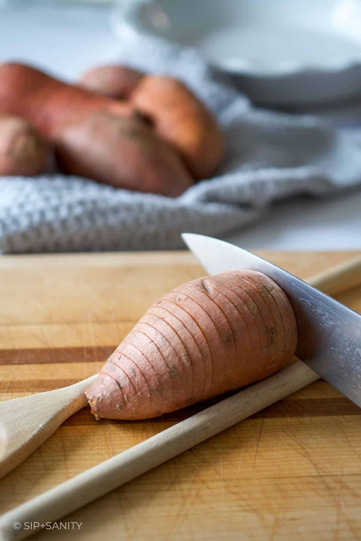 slicing a hasselback sweet potato