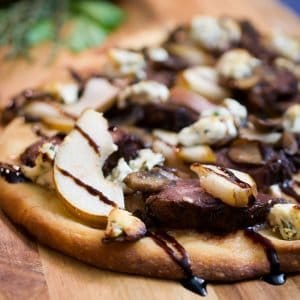 duck and mushroom pizza on a board