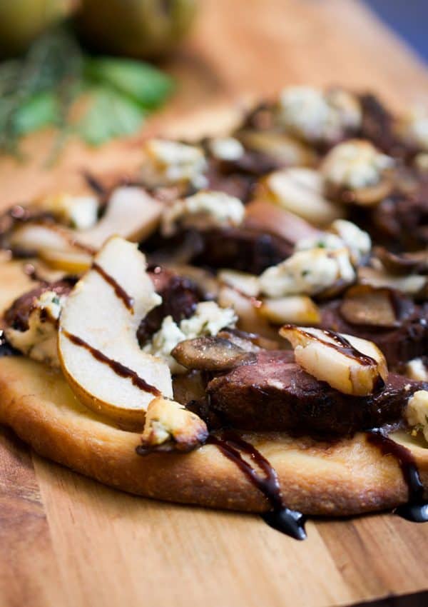 duck and mushroom pizza on a board