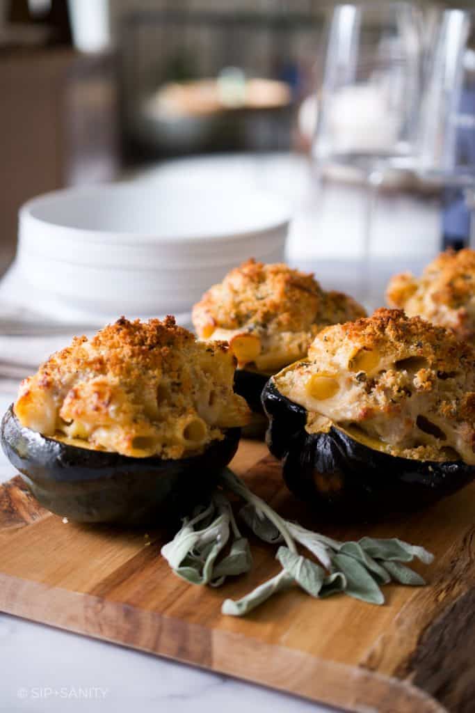 a tray of baked cheesy pasta with sausage stuffed acorn squash
