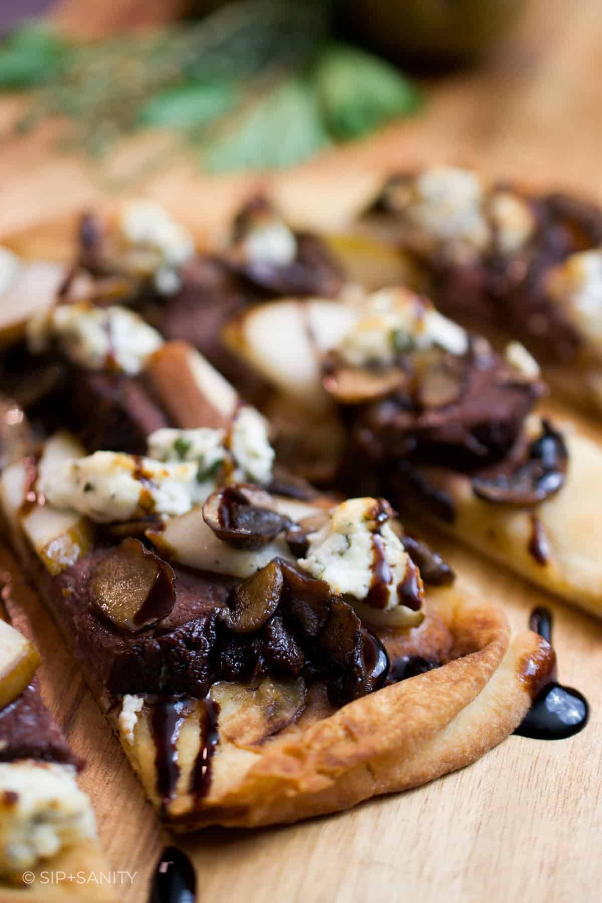slices of duck and mushroom pizza drizzled with balsamic