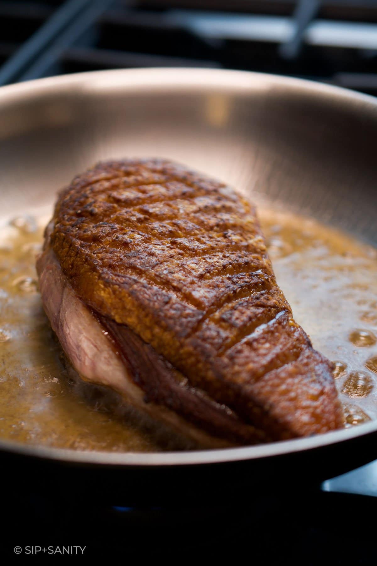 duck breast being seared in a pan