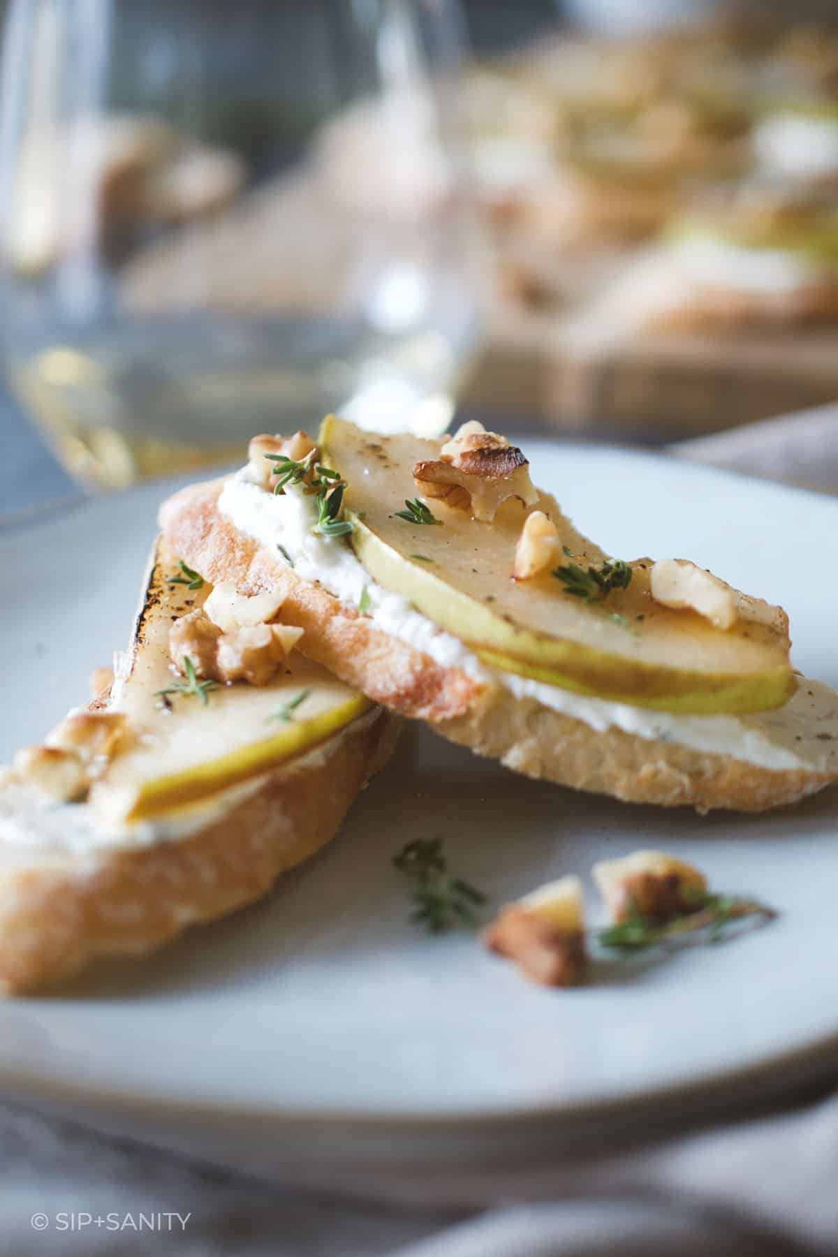two pear and feta crostini on a plate