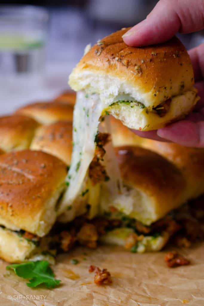 Pulling a slider sandwich with a trail of melty cheese.