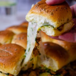 Pulling a slider sandwich with a trail of melty cheese.