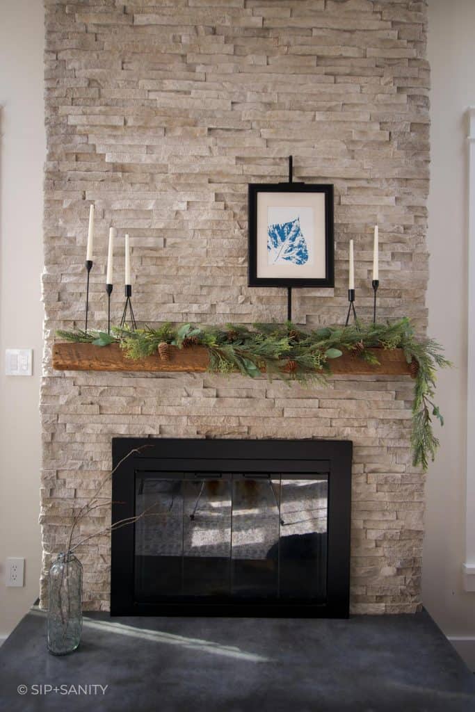A stacked stone fireplace with wood mantel.