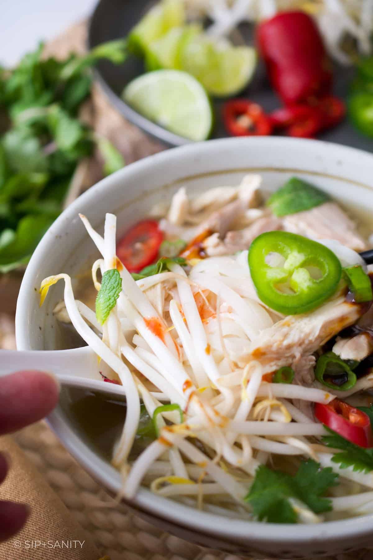 bowl of rotisserie chicken pho with garnishes