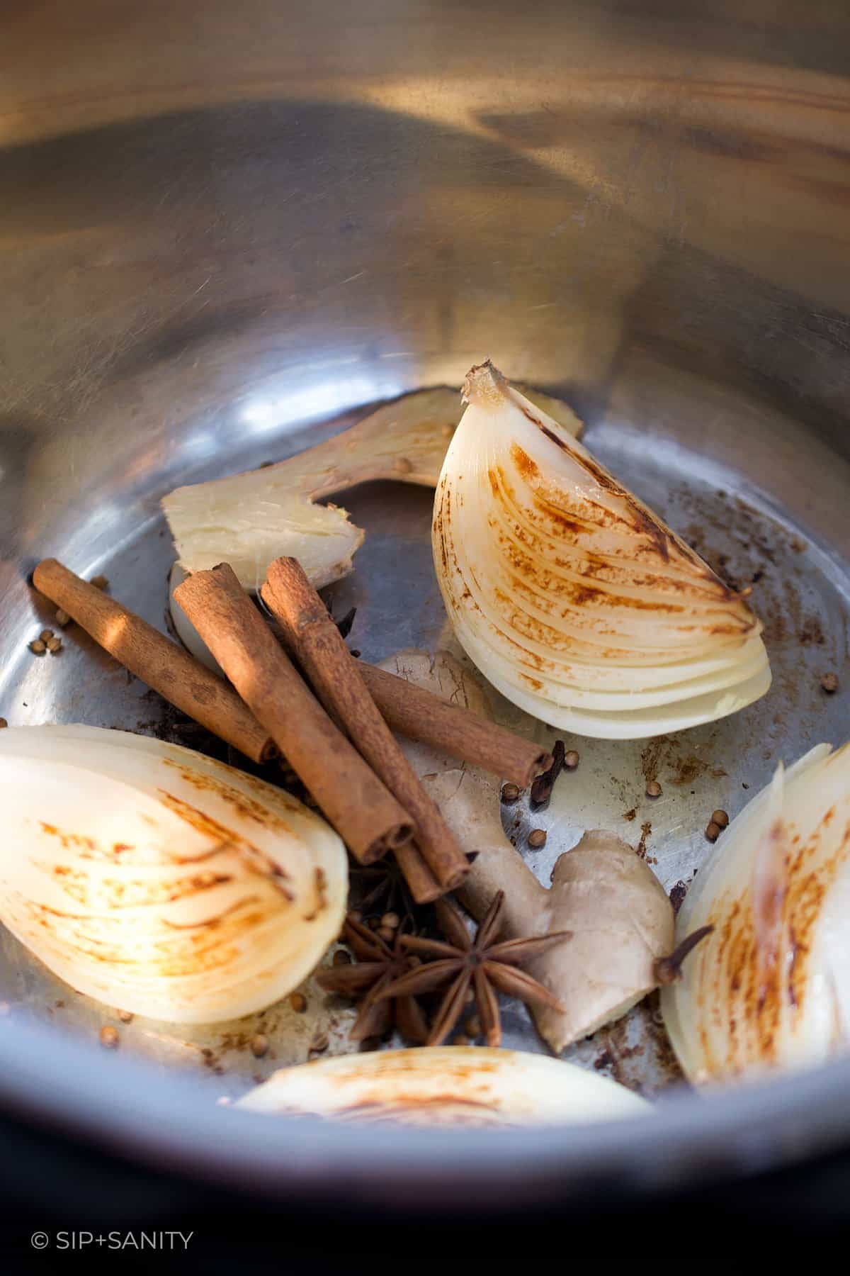 onions, cinnamon, star anise, ginger in a pot