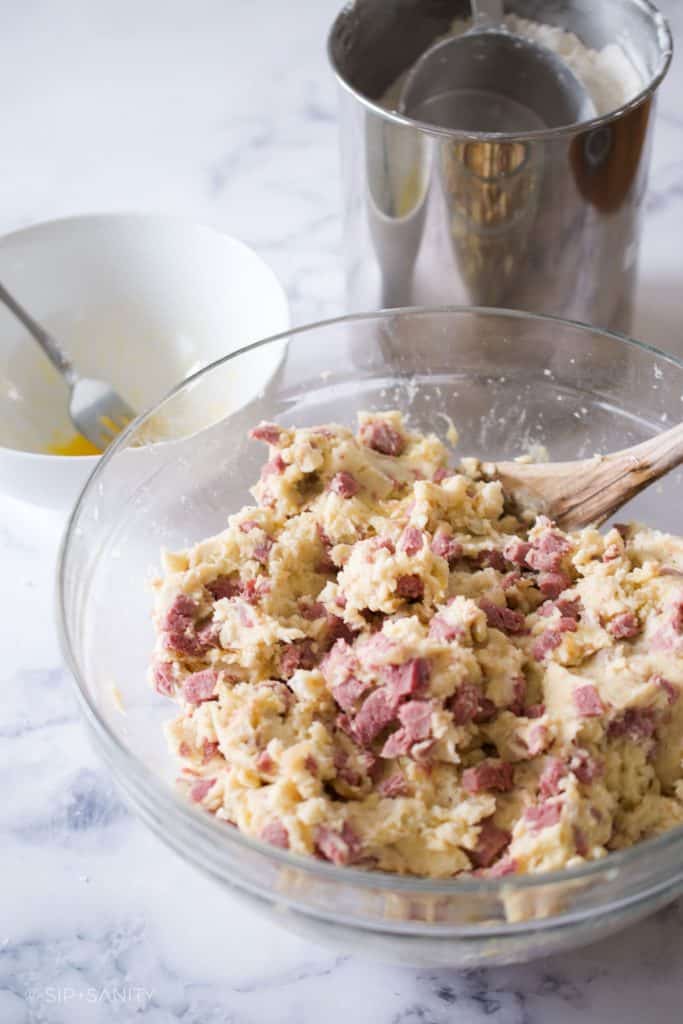 A mixture of mashed potatoes, onions and corned beef in a bowl.