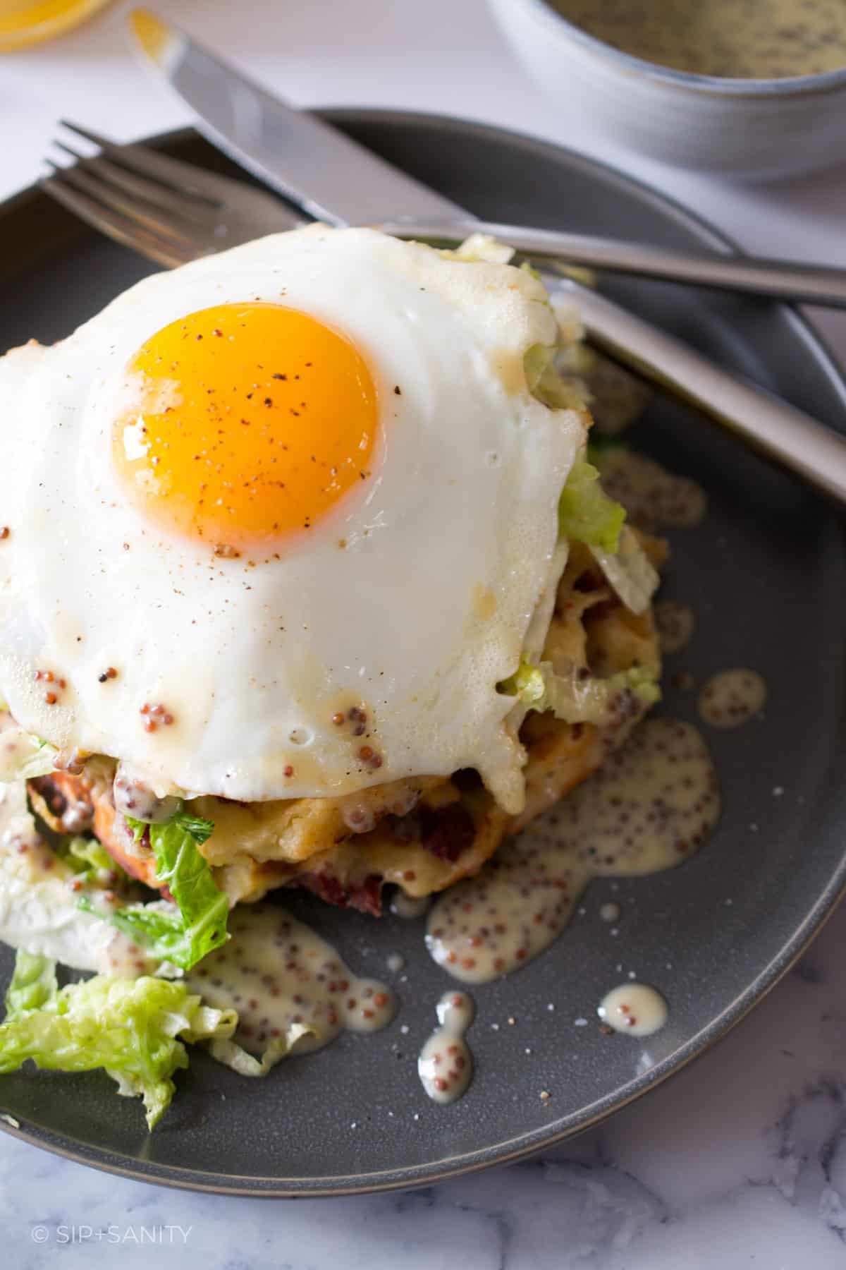Corned beef hash waffles topped with sautéed savoy cabbage and a fried egg.