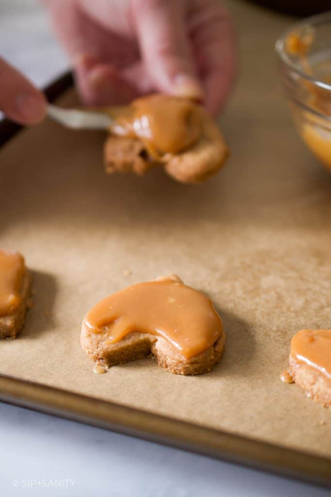 Spreading caramel on shortbread cookies.