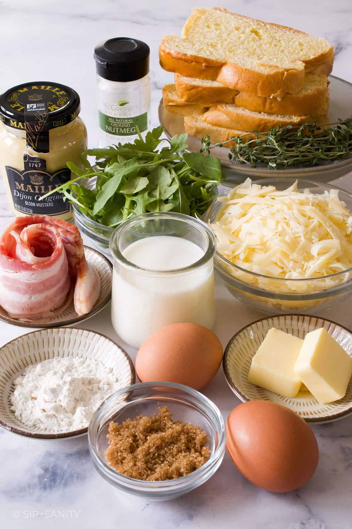 Raw ingredients for a croque madame on a white table.