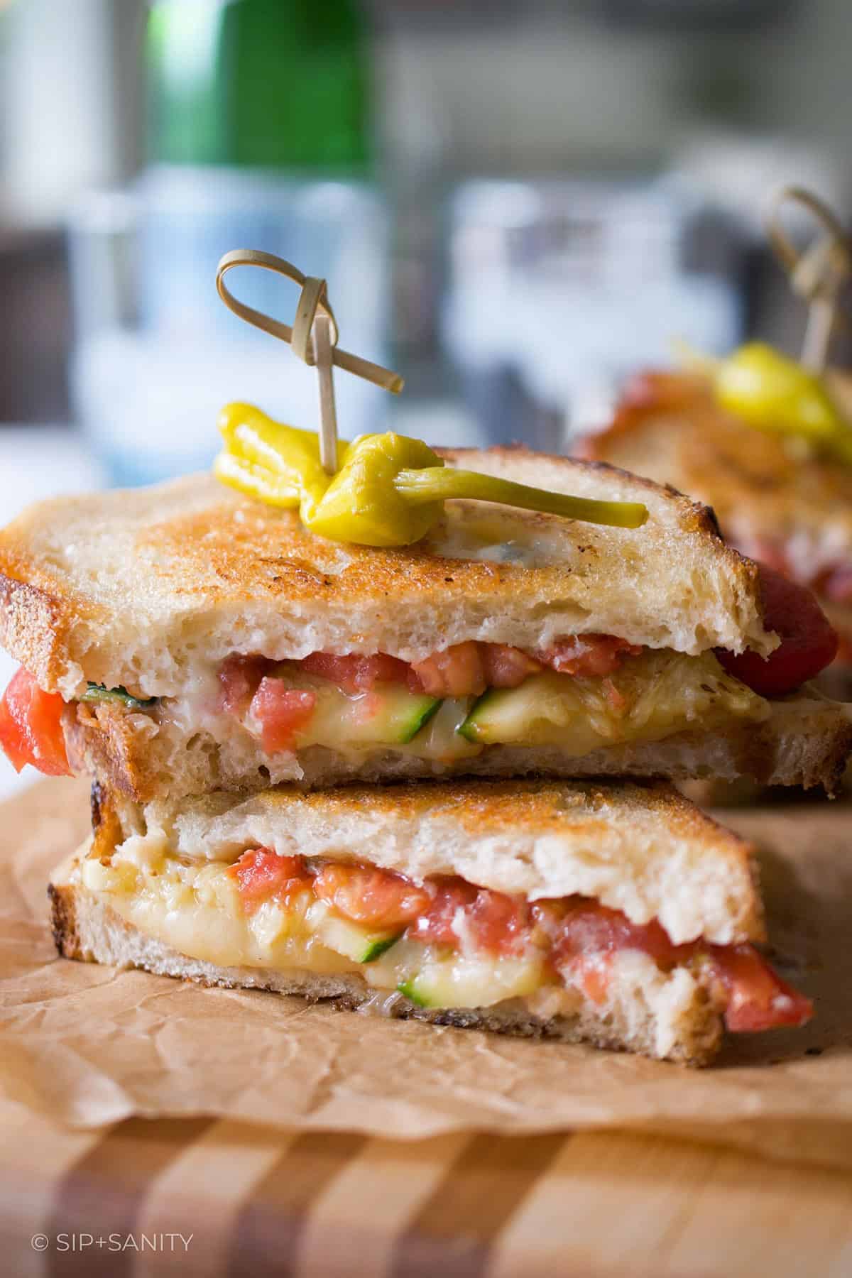 Two antipasto grilled cheese halves stacked on one another.