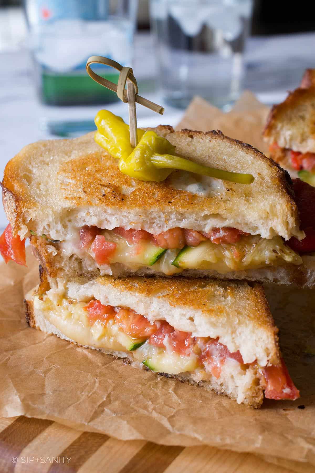 Two halves of a vegetarian antipasto grilled cheese sandwich.