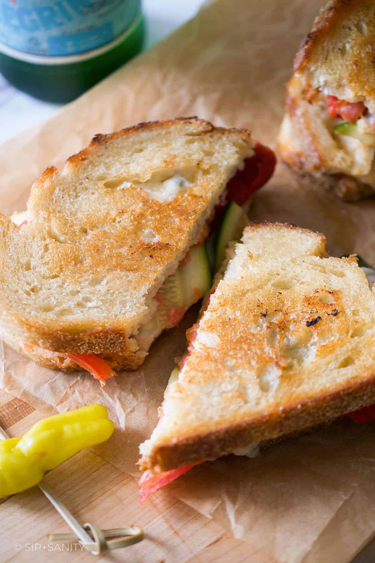 An antipasto grilled cheese sandwich on a cutting board.