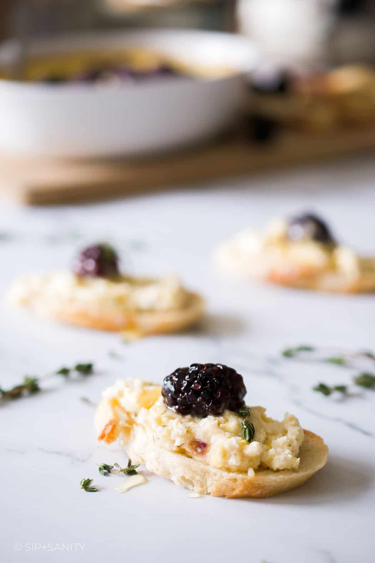 Three individual crostini topped with baked lemon ricotta dip.