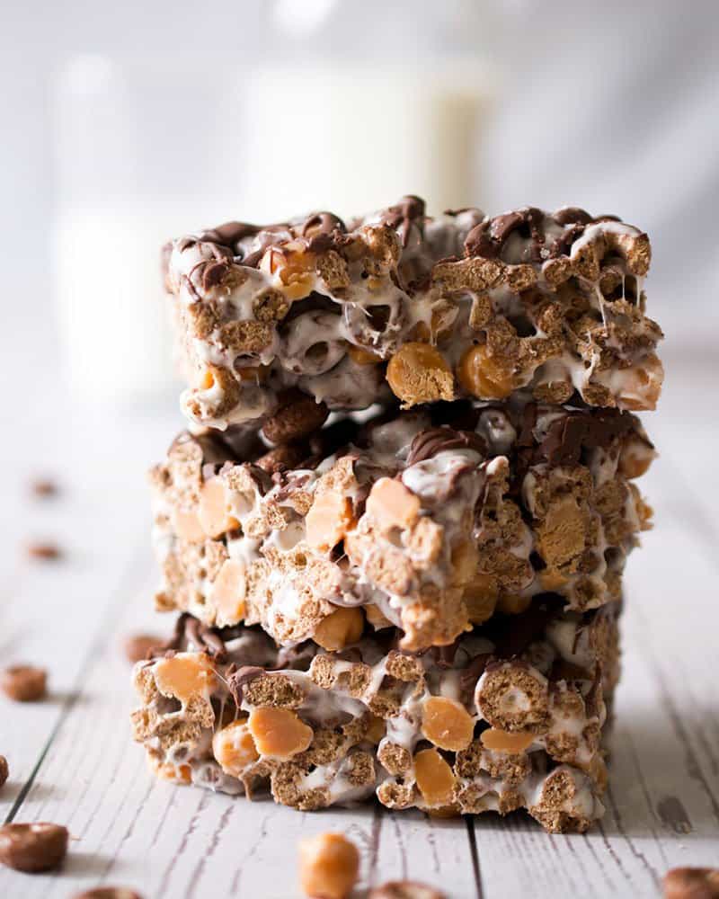 Stack of three salted caramel s'mores cereal bars on a wooden table.