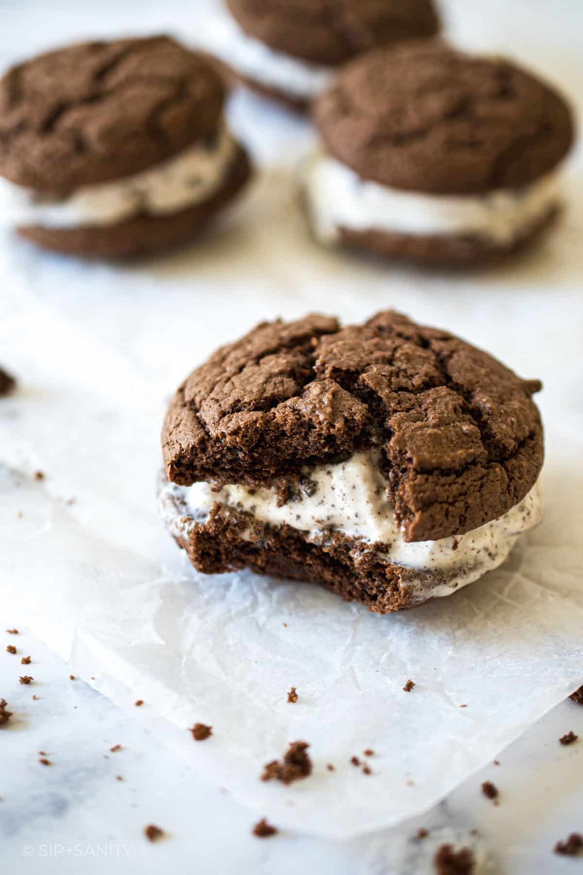 A cookie ice cream sandwich with a bite taken from it.