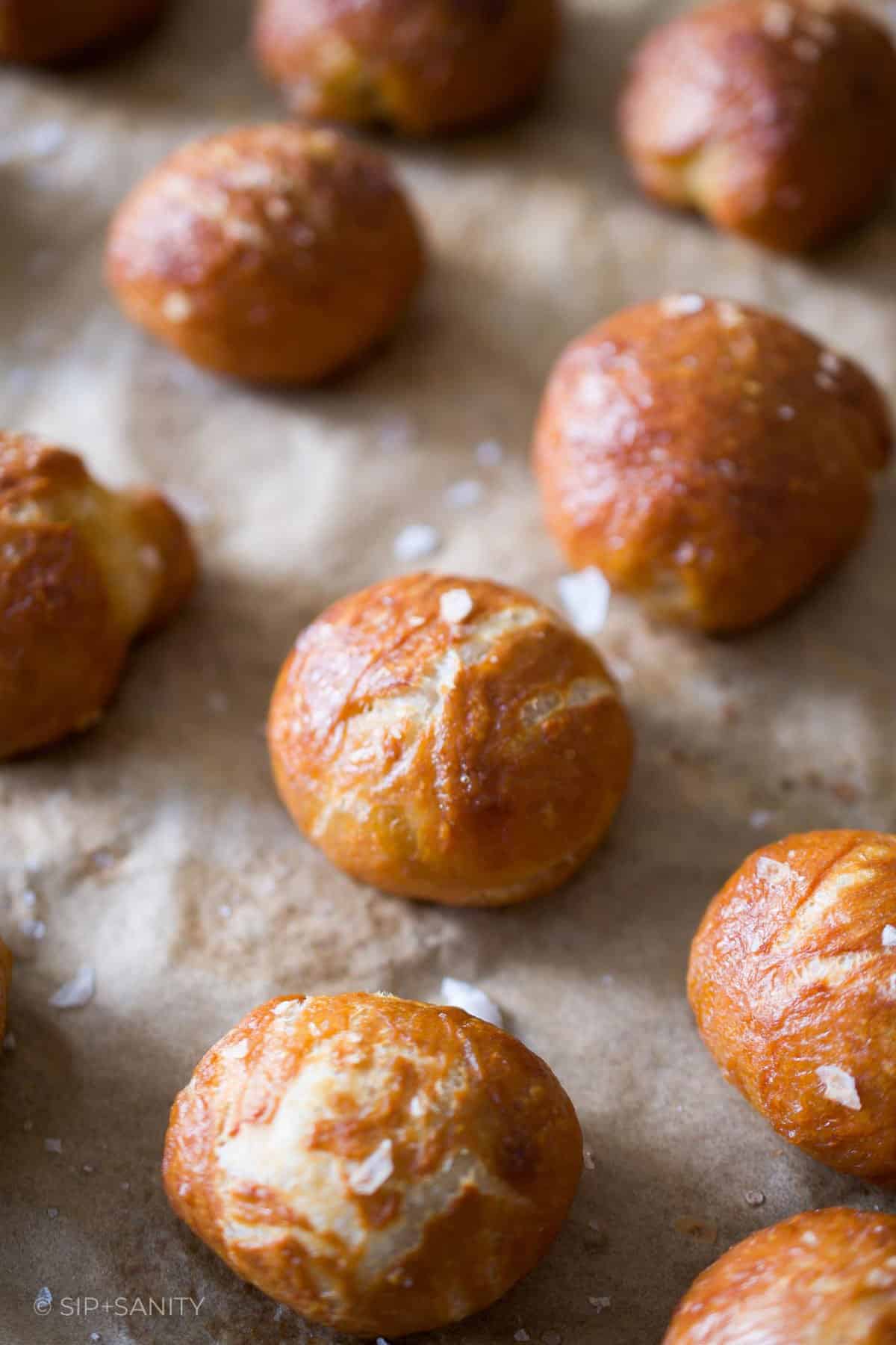 Rows of baked and salted pretzel bites on a sheet pan.