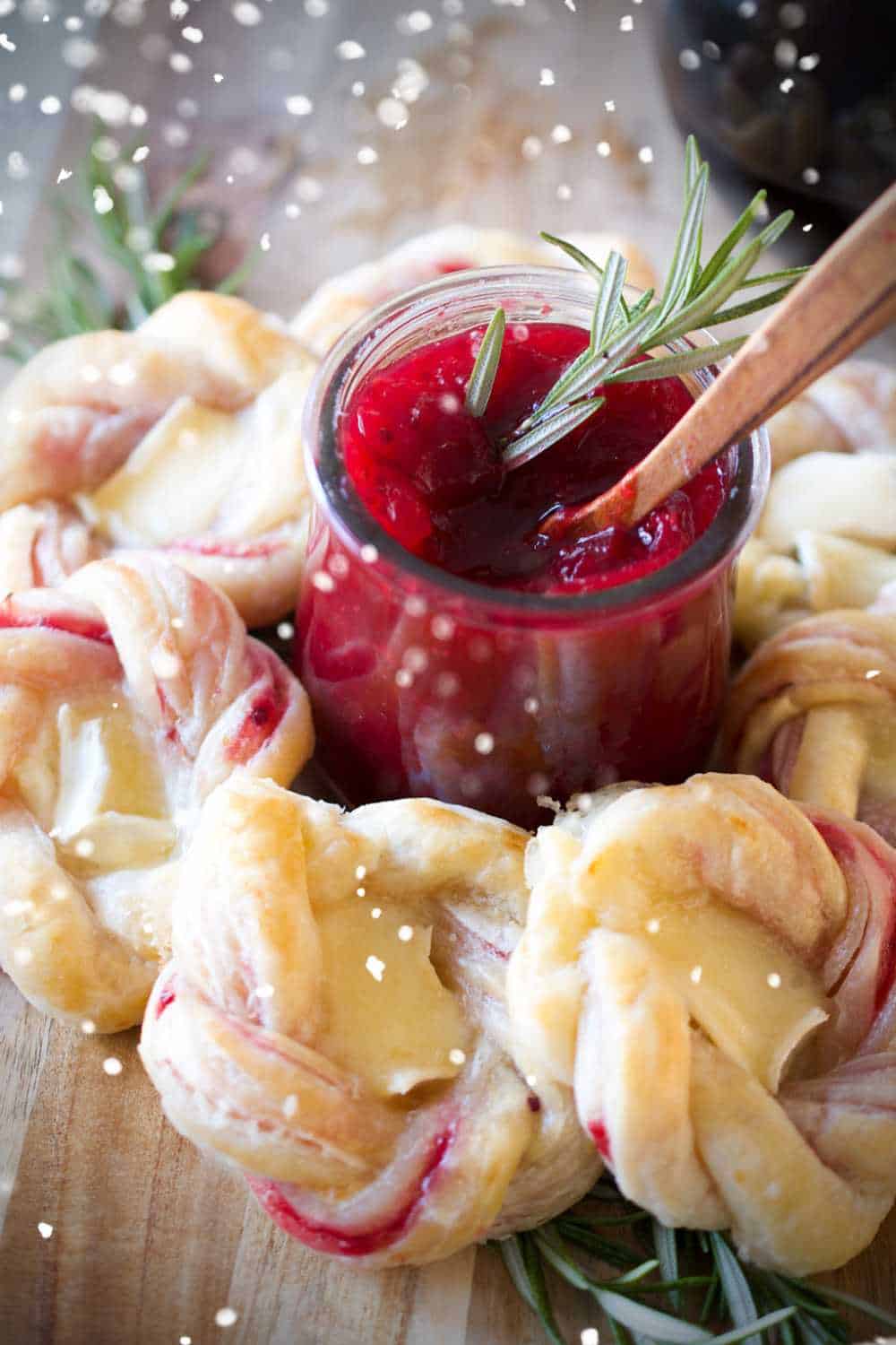 Cranberry and brie donut wreath around jar of cranberry jam.