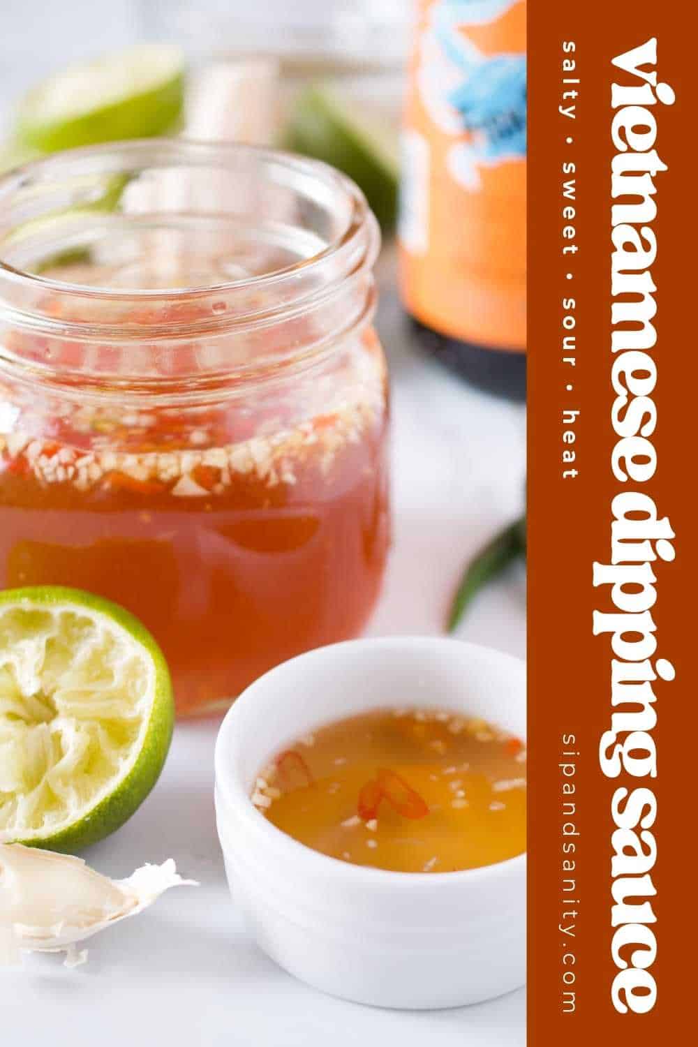 Jar and bowl of Nước chắm with garlic, chili, and lime, surrounded by limes, garlic, and a bottle. Text: salty, sweet, sour, heat.