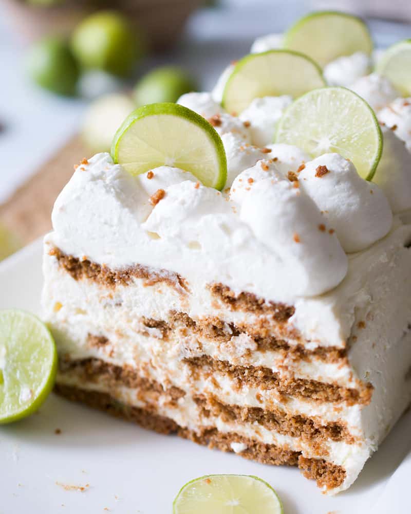 An icebox cake on a white platter with layers of ginger snaps and key lime cream.