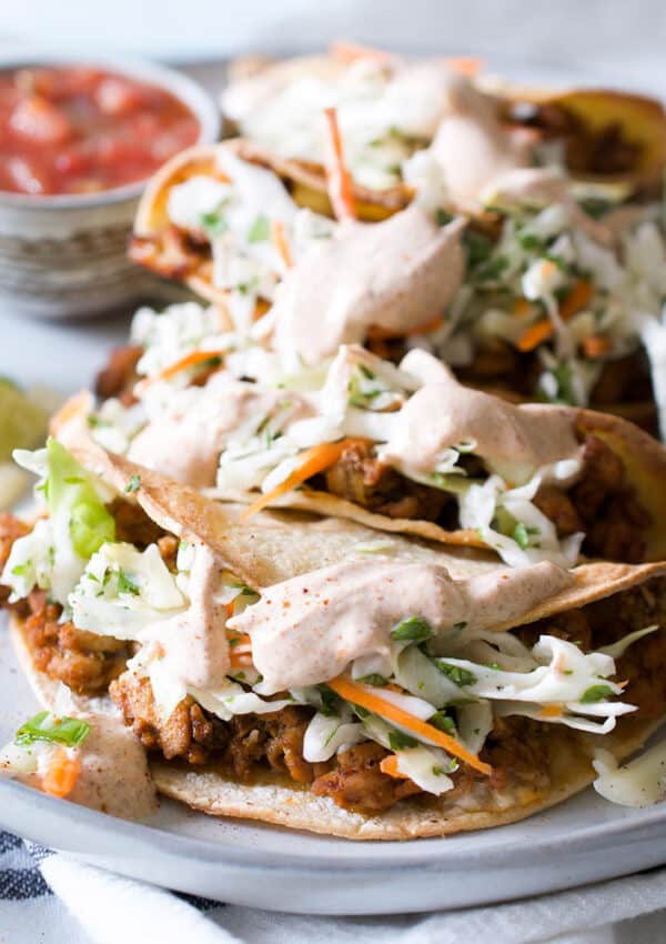 Crispy shell tacos stuffed with ground turkey and slaw on a white platter.