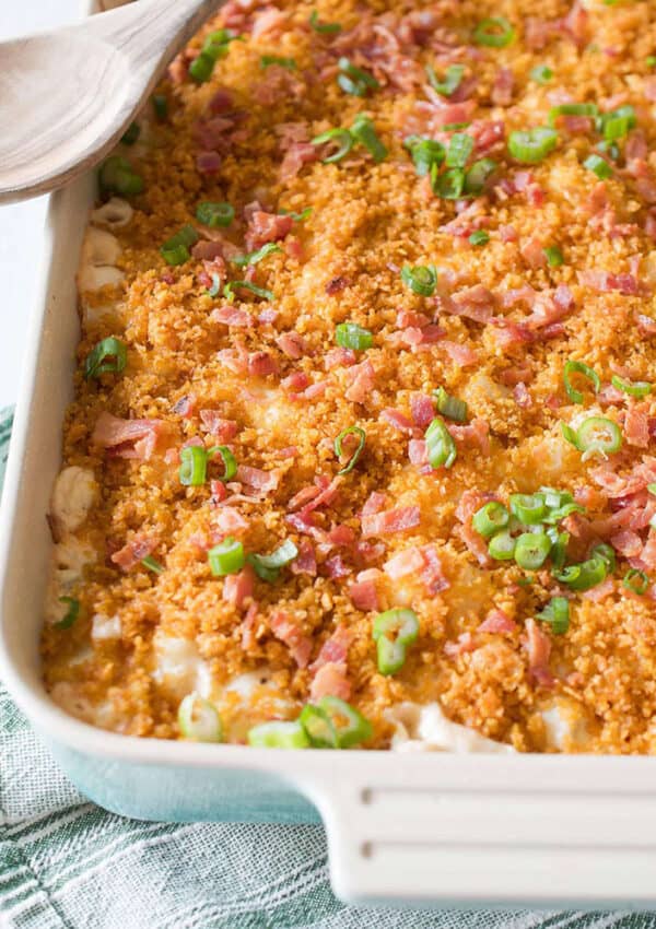 Rectangular casserole filled with cheesy hashbrowns topped with corn flakes and bacon crumbles.