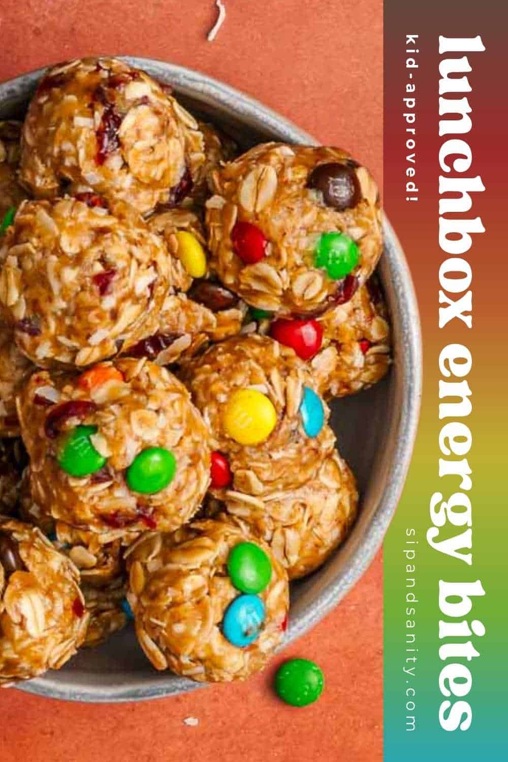 A bowl of oat energy bites mixed with colorful candies and dried fruit; text on the image reads: Lunchbox energy bites, kid-approved!