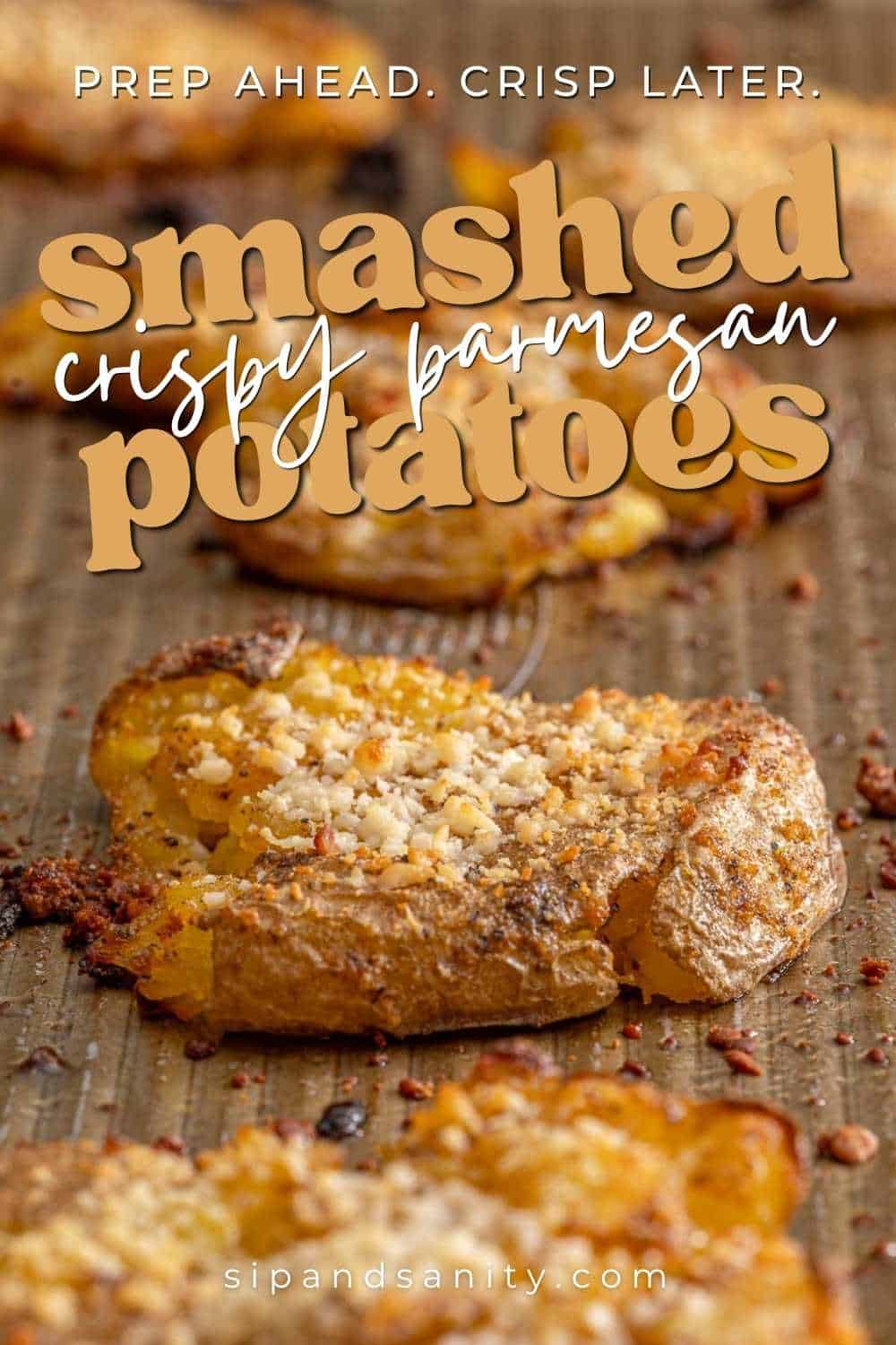 Golden smashed potatoes with parmesan on a baking sheet; text reads prep ahead, crisp later, smashed crispy parmesan potatoes.