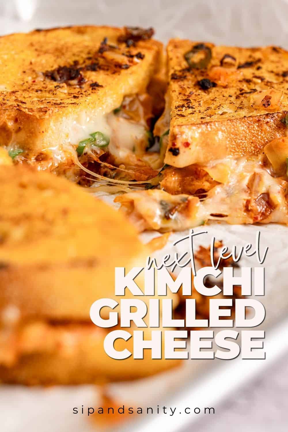 Gooey kimchi grilled cheese with melted cheese oozing out on parchment. Text: “Next Level Kimchi Grilled Cheese.”.
