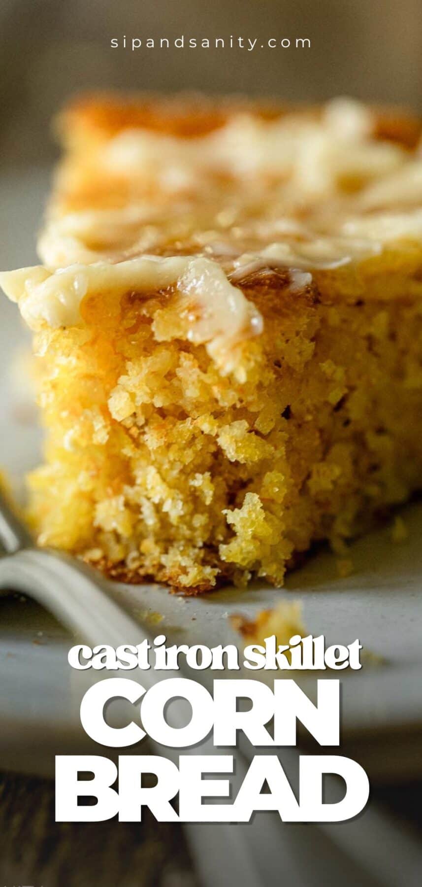 Thick skillet cornbread slice with melted butter on a plate, fork nearby. Image text: cast iron skillet CORN BREAD.