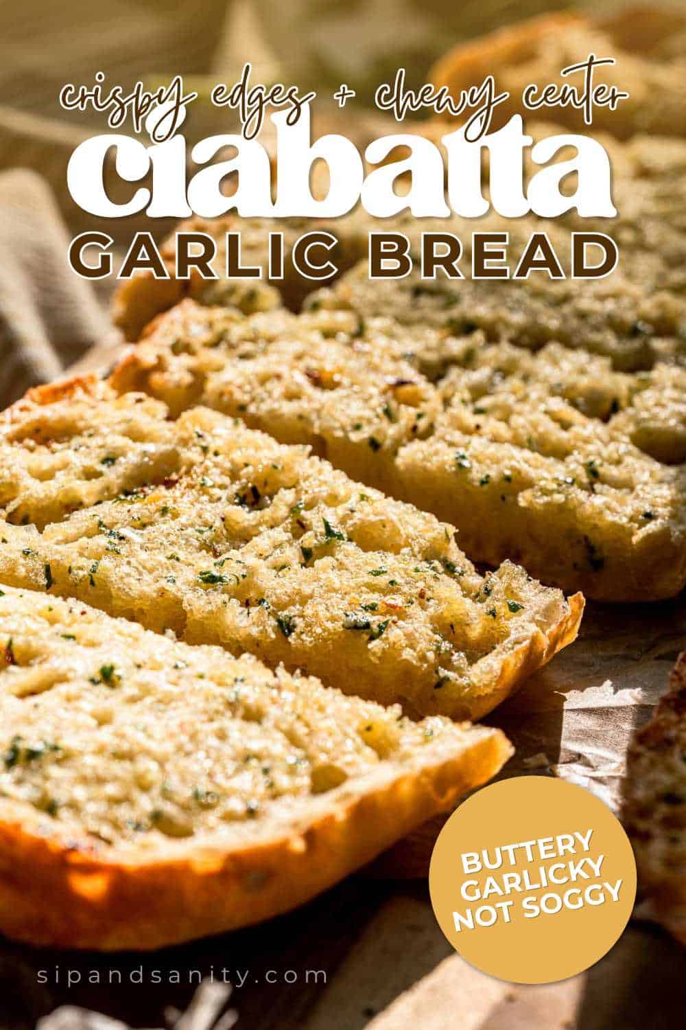 Sliced ciabatta garlic bread with golden crust, buttery garlic topping, crispy edges, and a chewy center on rustic surface.