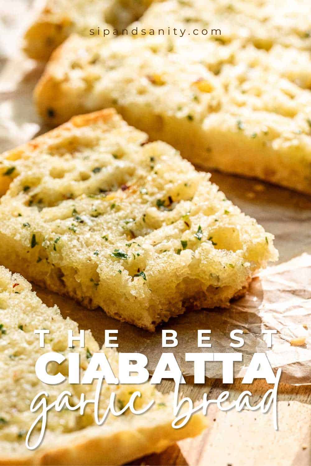 Sliced ciabatta garlic bread with herbs and melted butter on parchment. Text: The Best Ciabatta Garlic Bread.