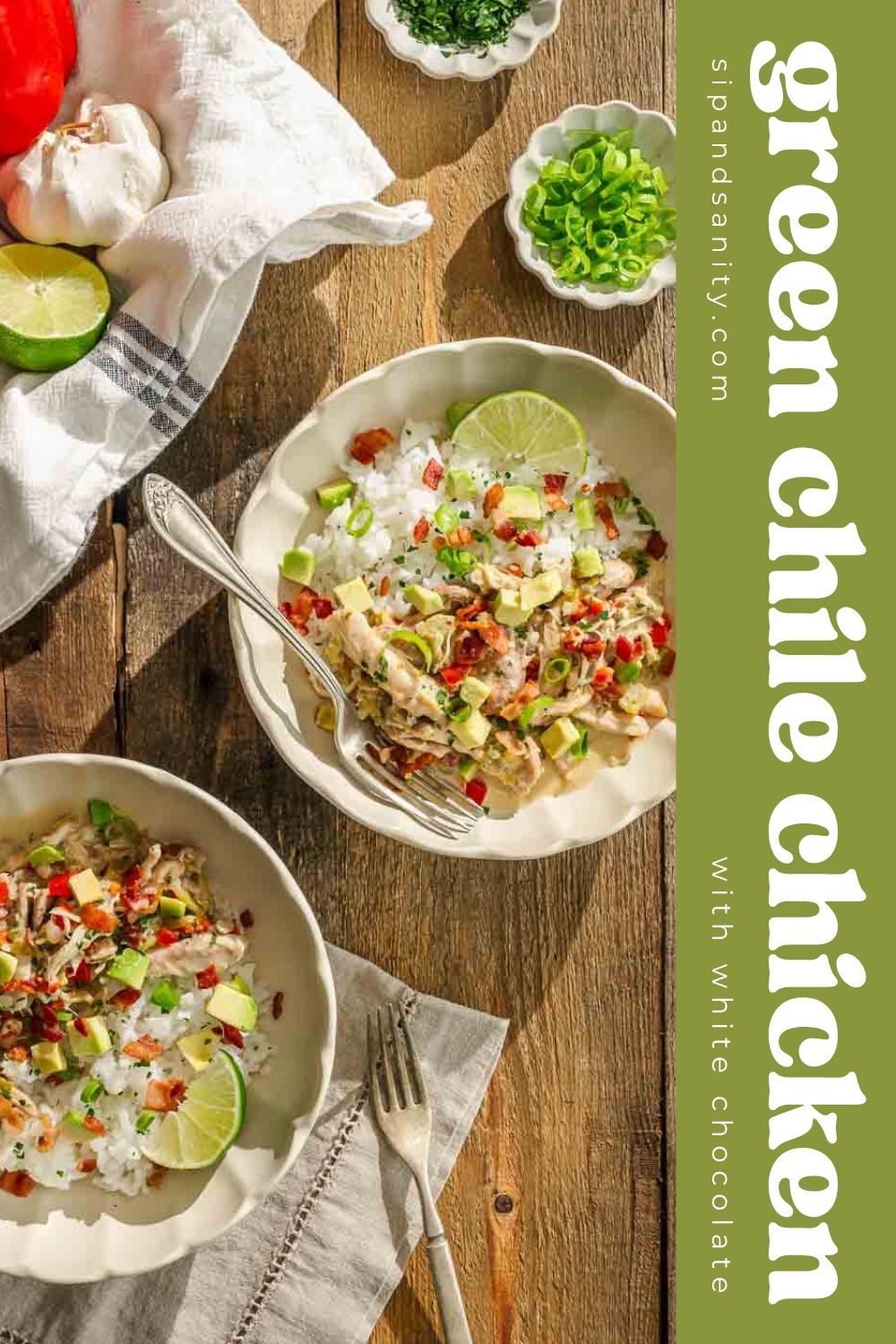 Two bowls of green chile chicken over rice with lime, avocado, and herbs on a table. Text: green chile chicken with white chocolate.