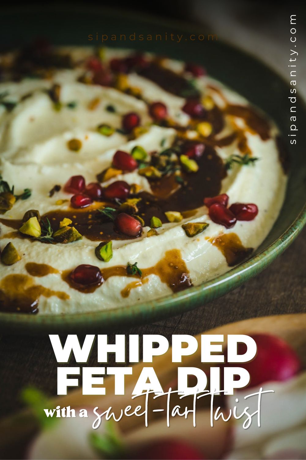 Whipped feta dip in a bowl topped with pomegranate seeds, pistachios, herbs, and balsamic glaze. Text: Sweet-tart twist.